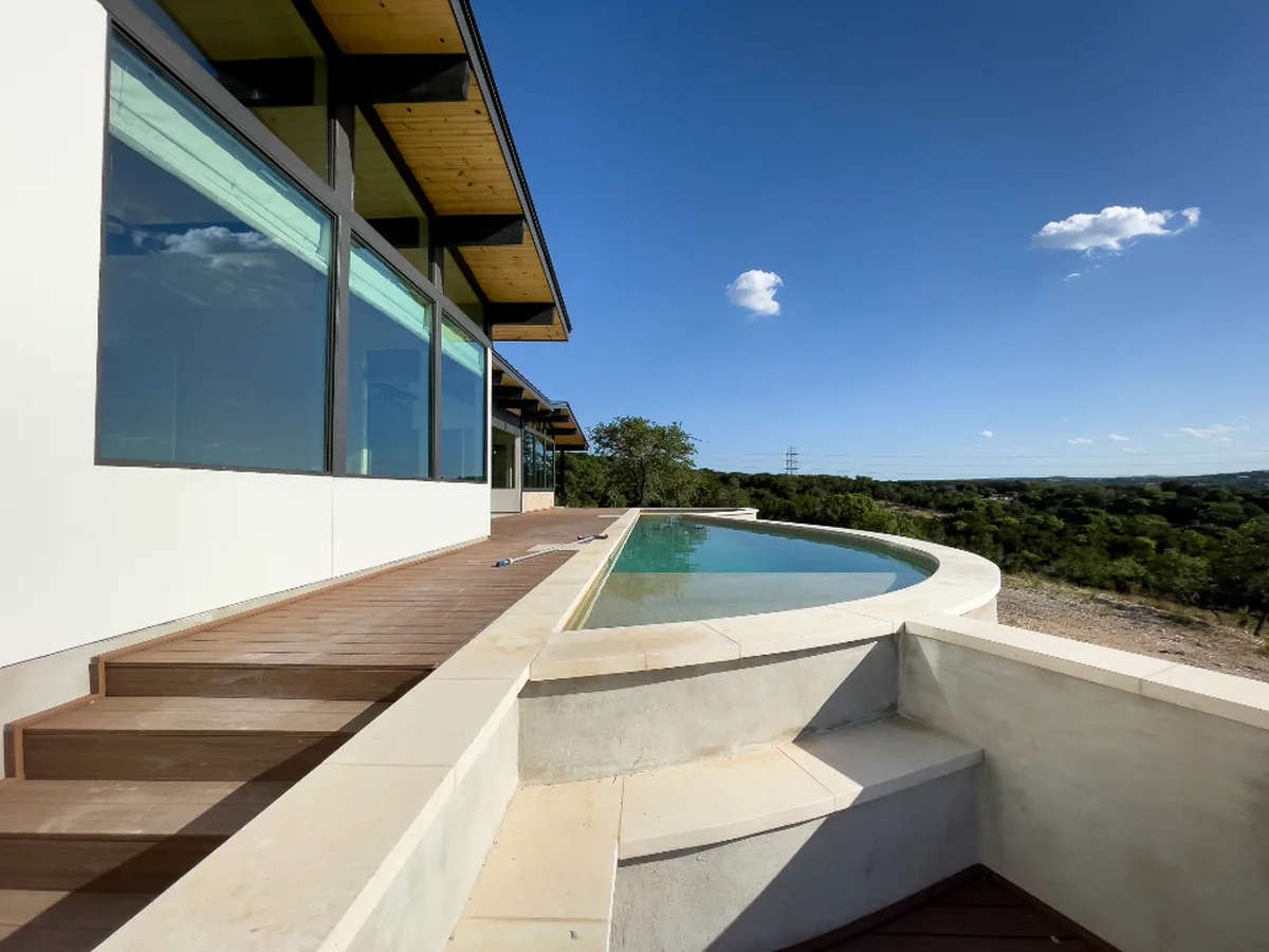 A modern residential property with a terrace and pool, overlooking open countryside.