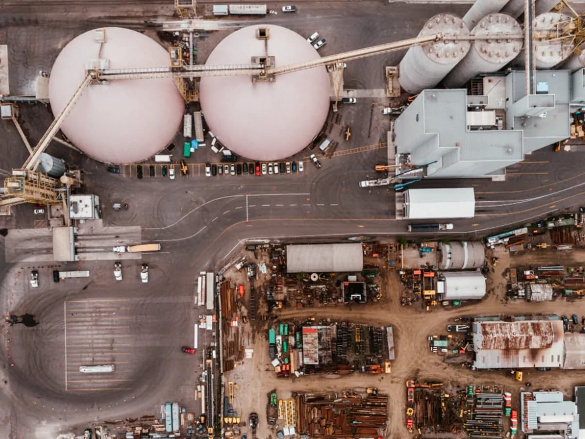 Aerial view of an industrial site, with storage tanks, access roads and loading yards laid out below.